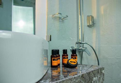 three bottles of essential oils sitting on a counter in a bathroom at Marchica Hotel in Nador