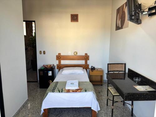 a small room with two beds and a table at Diplomata Hotel in Sertãozinho