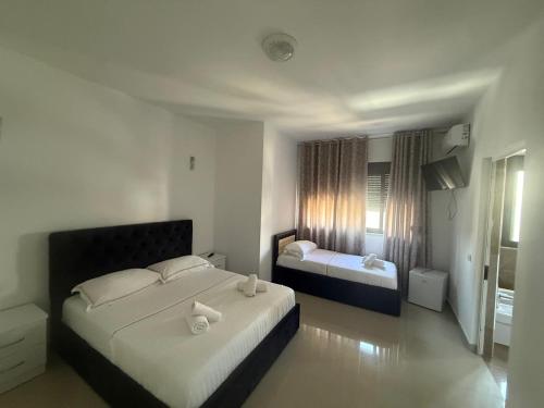 a bedroom with two beds with white sheets at Hotel Italia in Golem