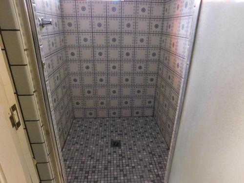 a bathroom with a shower with a tiled floor at Cliff Crest Inn in Santa Cruz