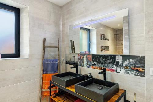 a bathroom with a black sink and a mirror at Chambres D'hôtes Bien-être Simple in Belvès