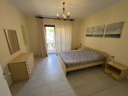 a bedroom with a bed and a table and a window at Casa vacanze Heidi con piscina in Marina di Bibbona