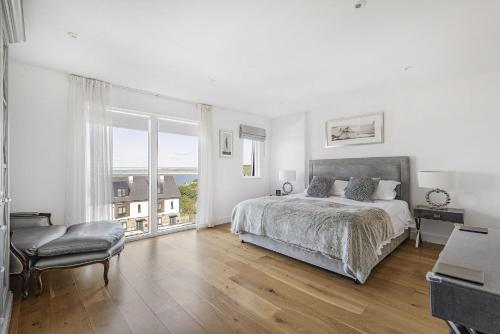 a white bedroom with a bed and a large window at 8 Salt in St Ives