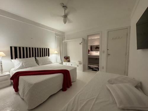 a white bedroom with a large bed and a closet at White House Canto in Búzios