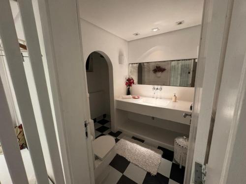 a bathroom with a sink and a mirror at White House Canto in Búzios