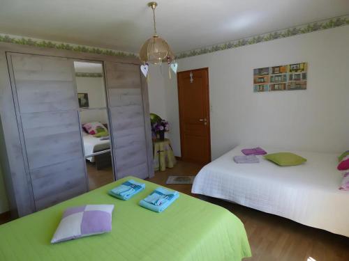 a bedroom with two beds and a mirror at Chambre d'hôtes les Rosiers in La Flèche