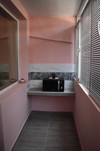 a microwave on a shelf in a room with a window at Апартамент за гости Лале in Lovech
