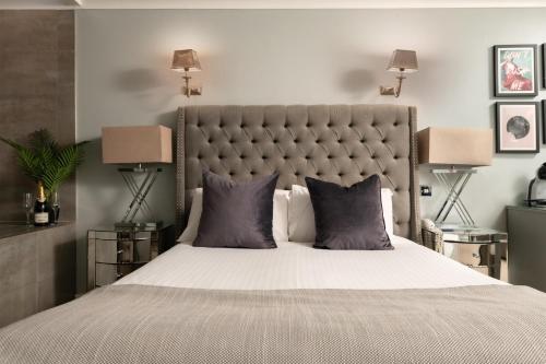 a bedroom with a large bed and two lamps at Birmingham North Moor Hall Hotel BW Premier Collection in Sutton Coldfield