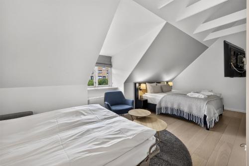 a hotel room with a bed and a chair at Gentofte Hotel in Gentofte