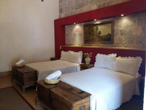 una camera con due letti e una foto a parete di Casa Limonchelo Hotel B&B a Morelia