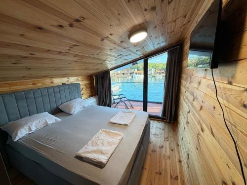 a large bed in a wooden room with a window at NiL Cottage in Ulcinj