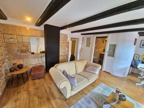 ein Wohnzimmer mit einer Couch und einer Steinwand in der Unterkunft Bed Bentheim in Bad Bentheim