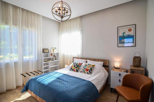a bedroom with a bed and a chair and a window at Karivaliko in Vrontádos
