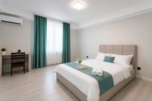 a bedroom with a large bed with green curtains and a desk at Saltanat hotel in Alghabas