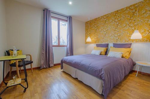 a bedroom with a bed and a table and a window at La petite maison dans lusigny in Lusigny-sur-Barse