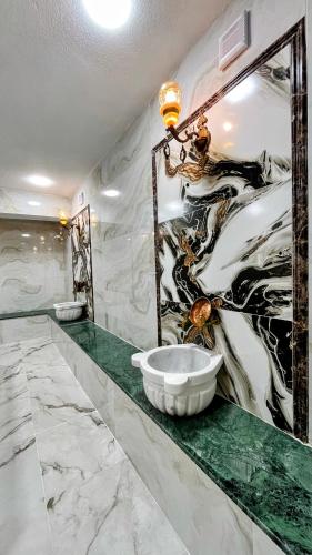 a bathroom with a large painting on the wall at Zarina Hotels & Hamam in Batumi