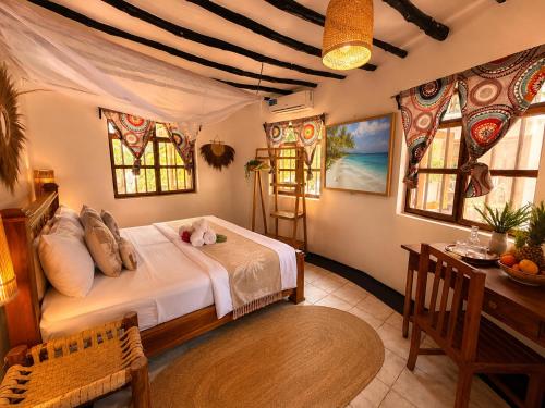 a bedroom with a bed in a room with windows at Tiki Beach Club & Resort in Paje