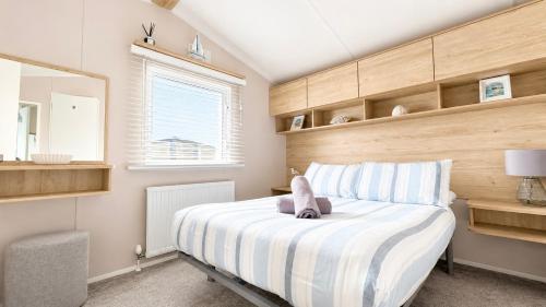 a bedroom with a bed with a stuffed animal on it at Tide & Anchor - Newperran 102 in Cubert