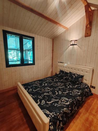 a bedroom with a bed and a window at Le chalet Campy in Moustier