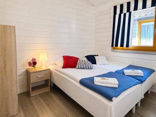 a bedroom with a bed and a table with a night stand at Mielenko Domki Wakacyjny Raj in Mielenko