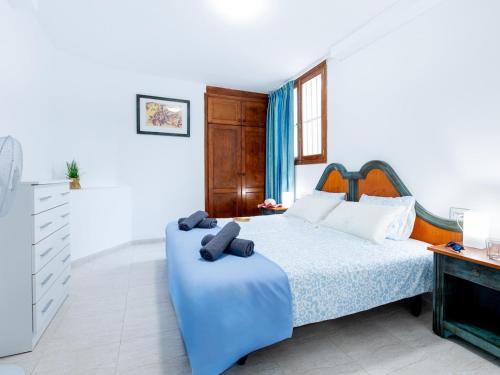 a bedroom with a large bed with a blue blanket at Cute Las Flores 1i with pool in Costa de Adeje