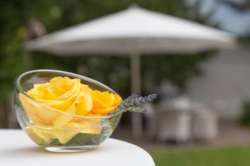a glass bowl filled with yellow flowers on a table at Hotel-Restaurant Arneggers Adler in Tiefenbronn