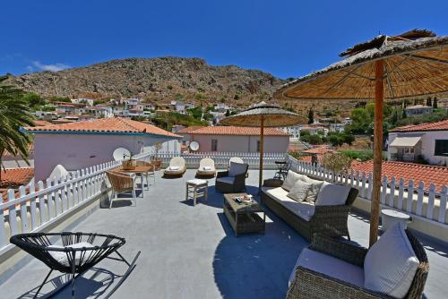 a patio with chairs and tables and umbrellas at Unique luxury suites in Hydra