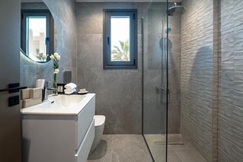 a bathroom with a shower and a toilet and a sink at Avenue by Deserve in Paphos