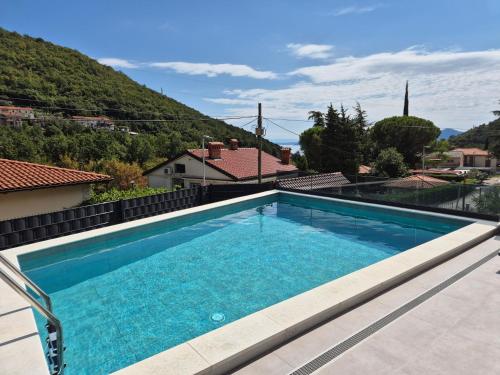 a swimming pool with a mountain in the background at Villa Aylen in Mošćenička Draga