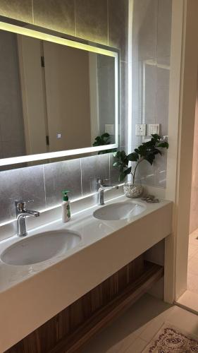 a bathroom with two sinks and a large mirror at شقه دار المشاعر فى دار الاركان لشقق لاكجرى in Mecca