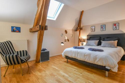 a bedroom with a large bed and a chair at Kermajic 10 in Villiers-Saint-Georges