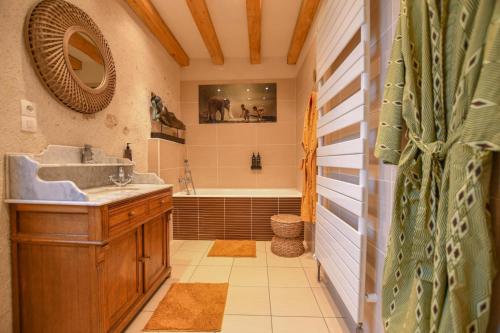 a bathroom with a sink and a tub and a mirror at Kermajic 10 in Villiers-Saint-Georges