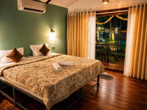 a bedroom with a large bed and a window at Seashell Cottages Palolem in Canacona