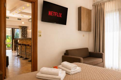 a hotel room with a bed and a chair and a television at Kladis Club Holidays in Skala Potamias