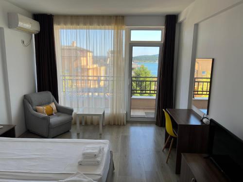 a hotel room with a bed and a desk and a window at Family Hotel Dreams in Sozopol