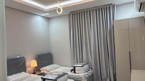 a hotel room with two beds and a window at شقه دار المشاعر فى دار الاركان لشقق لاكجرى in Mecca