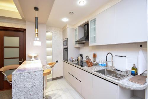 a kitchen with white cabinets and a sink at Nord Gate Avenue Hotel in Yerevan