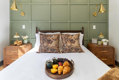 a bed with a bowl of bread and a bowl of fruit at Harvard Charm Near Boston New build in Cambridge