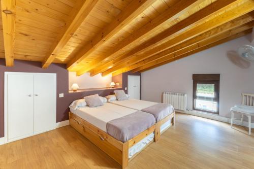 a bedroom with a bed and wooden ceilings at Paraje Navazos in Gavilanes