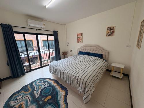 a bedroom with a bed and a large window at Maolao bar and hotel in Pai