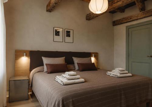 a bedroom with a large bed with towels on it at Ausma Hotel in Kuldīga