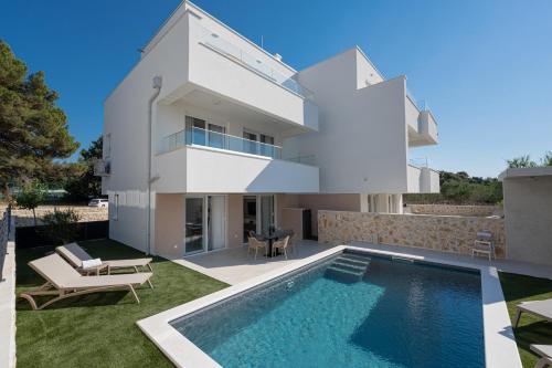 a villa with a swimming pool and a house at Smash A - Apartments with Private Pool in Novalja