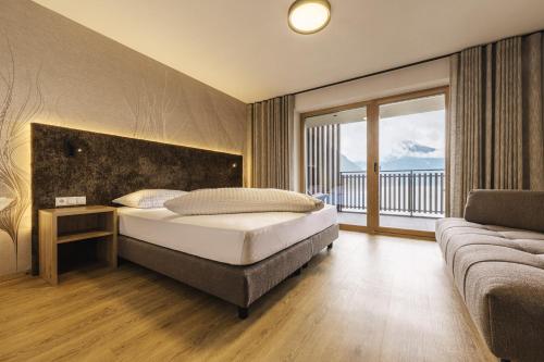 a bedroom with a bed and a large window at Residence Froy in Resia