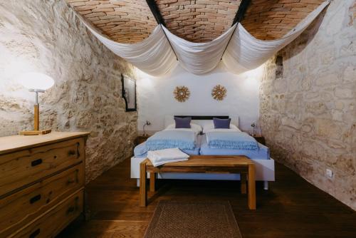 a bedroom with a bed in a stone walled room at Casa.Peiso in Mörbisch am See