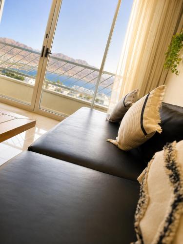 a black couch in a room with a large window at Milano Suite in Lev Eilat in Eilat