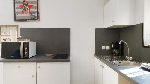 a kitchen with a sink and a microwave on a counter at Gites de l'hivet in Merdrignac