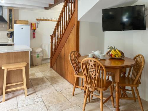a kitchen and dining room with a wooden table and chairs at Small Barn - Uk52140 in Liskeard