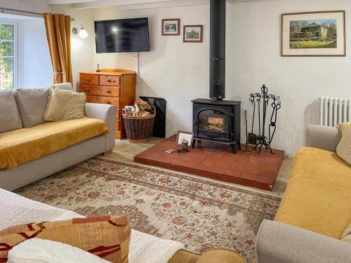 a living room with a fireplace and a couch at Henwood Barn - Uk52138 in Liskeard