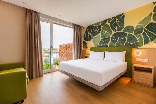 a bedroom with a large white bed and a window at Spirit Hotel Fonte Real in Monte Real