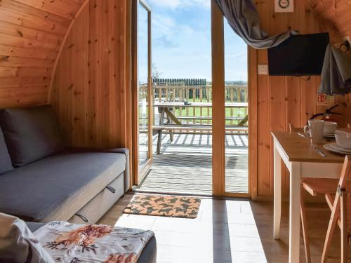 a room with a couch and a balcony with a table at Manx View-Uk1396 in Corney